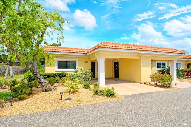 4840 Gulf Of Mexico Dr Unit 15, Longboat Key, FL 34228 - view of front facade featuring concrete driveway, a carport, stucco siding, and a tile roof