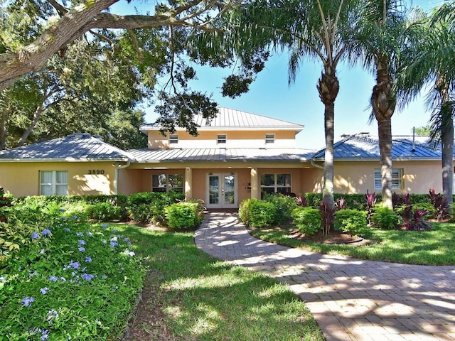 4550 Pinebrook Cir Unit 608, Bradenton, FL 34209 - view of front facade with french doors, a standing seam roof, stucco siding, metal roof, and a front lawn