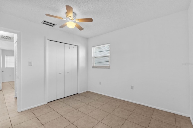 505 47th Avenue Dr W, Bradenton, FL 34207 - unfurnished bedroom with a textured ceiling, a closet, light tile patterned flooring, baseboards, and ceiling fan