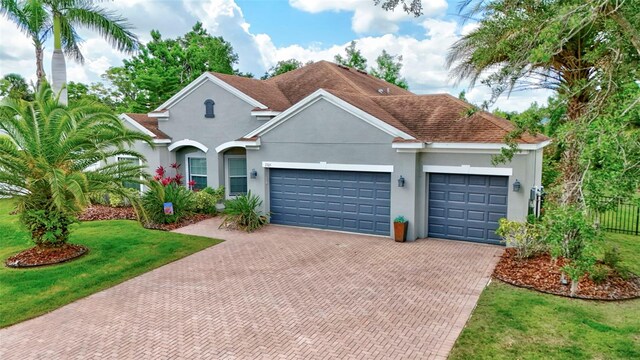 7705 55th St E, Ellenton, FL 34222 - view of front facade featuring decorative driveway, an attached garage, and stucco siding