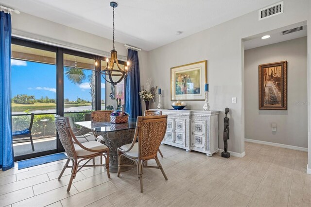 23528 Awabuki Dr Unit 101, Venice, FL 34293 - dining room featuring a chandelier, baseboards, and a water view