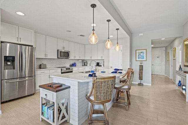 23528 Awabuki Dr Unit 101, Venice, FL 34293 - kitchen with stainless steel appliances, a sink, white cabinetry, light countertops, and recessed lighting