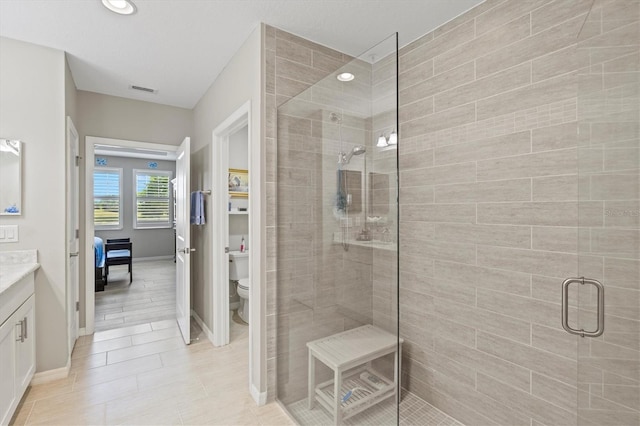 23528 Awabuki Dr Unit 101, Venice, FL 34293 - ensuite bathroom featuring a shower stall, toilet, vanity, baseboards, and recessed lighting