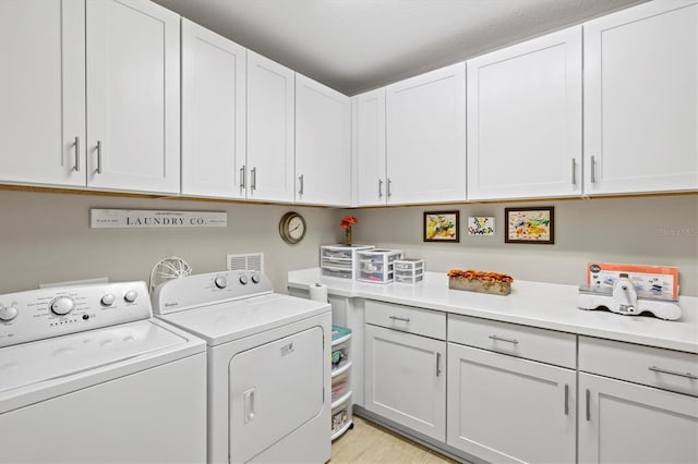 23528 Awabuki Dr Unit 101, Venice, FL 34293 - laundry area featuring independent washer and dryer, cabinet space, and light wood-type flooring