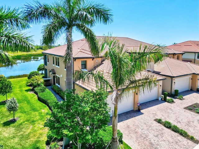 23528 Awabuki Dr Unit 101, Venice, FL 34293 - view of front of house with decorative driveway, a tile roof, stucco siding, and an attached garage