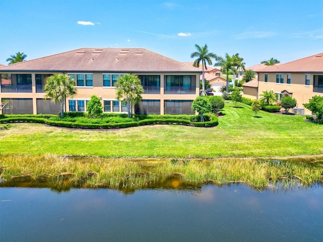 23528 Awabuki Dr Unit 101, Venice, FL 34293 - rear view of house featuring a water view, a tile roof, and a lawn