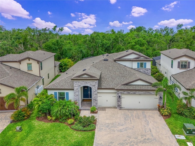 8916 Isabella Cir, Parrish, FL 34219 - view of front of property featuring decorative driveway, a garage, a shingled roof, and stucco siding