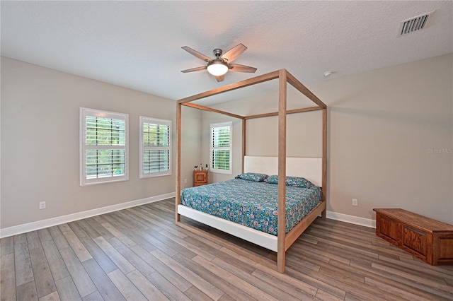 8916 Isabella Cir, Parrish, FL 34219 - bedroom featuring wood finished floors, baseboards, ceiling fan, and a textured ceiling