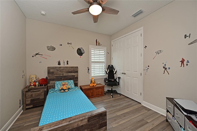 8916 Isabella Cir, Parrish, FL 34219 - bedroom featuring light wood finished floors, baseboards, a ceiling fan, and a textured ceiling