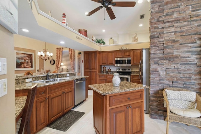 4804 Jacaranda Heights Dr, Venice, FL 34293 - kitchen featuring stainless steel appliances, a ceiling fan, brown cabinetry, light stone countertops, and a sink