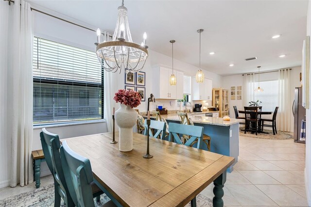 dining space with a chandelier, light tile patterned flooring, and recessed lighting