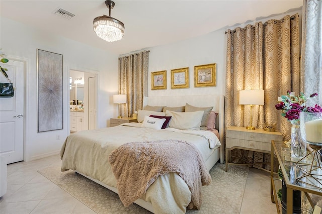 bedroom featuring light tile patterned floors, a chandelier, and ensuite bath