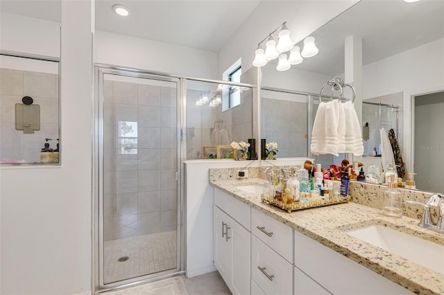 bathroom featuring a shower stall, double vanity, and tile patterned floors
