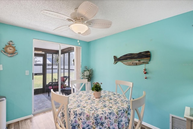 217 High Point Dr Unit 217A, Englewood, FL 34223 - dining room with wood finished floors, baseboards, a textured ceiling, and ceiling fan