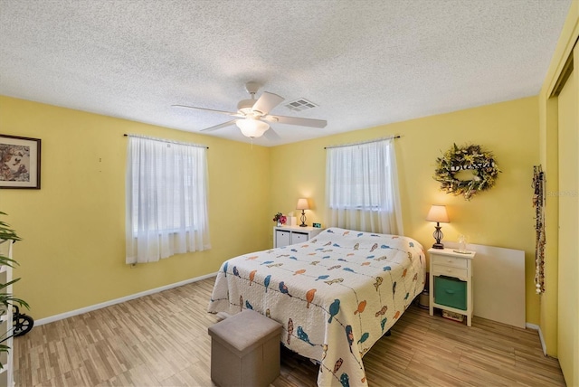 217 High Point Dr Unit 217A, Englewood, FL 34223 - bedroom featuring wood finished floors, a ceiling fan, a textured ceiling, baseboards, and a closet