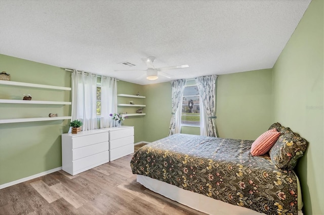 217 High Point Dr Unit 217A, Englewood, FL 34223 - bedroom featuring wood finished floors, a textured ceiling, a ceiling fan, and baseboards