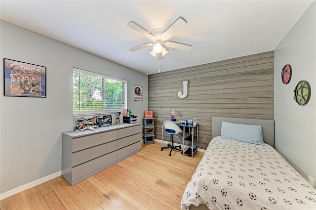 4115 2nd Ave NW, Bradenton, FL 34209 - bedroom with an accent wall, light wood-style flooring, wood walls, baseboards, and ceiling fan