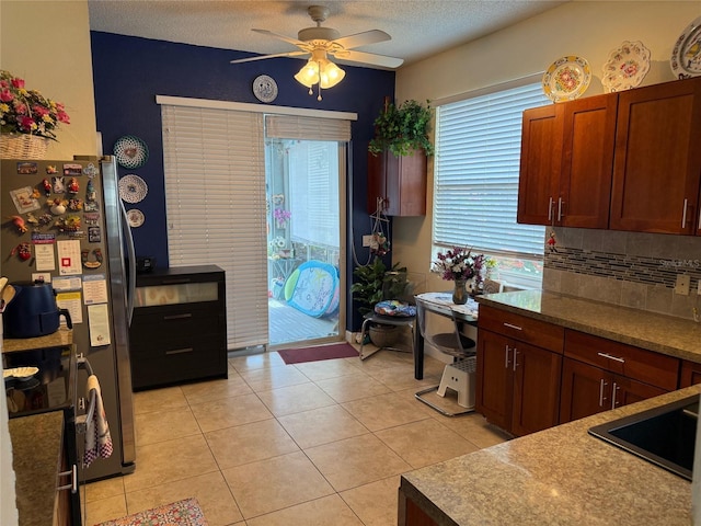 817 Tallgrass Ln, Bradenton, FL 34212 - kitchen featuring a ceiling fan, freestanding refrigerator, light tile patterned flooring, tasteful backsplash, and a textured ceiling