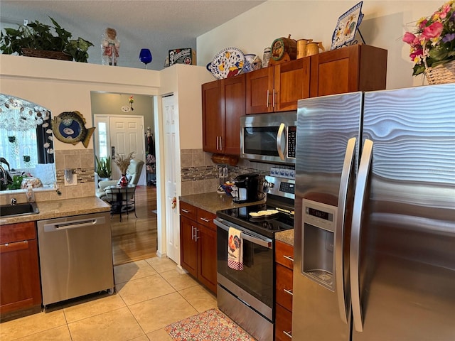 817 Tallgrass Ln, Bradenton, FL 34212 - kitchen featuring appliances with stainless steel finishes, decorative backsplash, light tile patterned flooring, and a sink