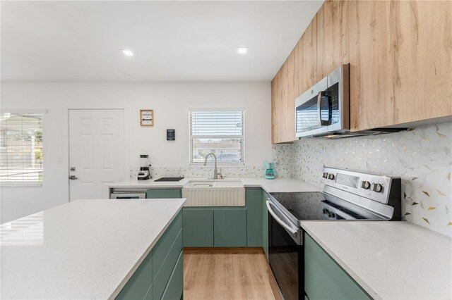 2715 Herwald St, Sarasota, FL 34231 - kitchen featuring green cabinets, range with electric stovetop, stainless steel microwave, and light wood finished floors