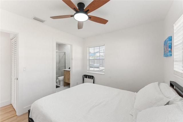 2715 Herwald St, Sarasota, FL 34231 - bedroom with light wood finished floors, ensuite bathroom, ceiling fan, and baseboards