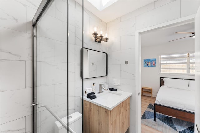 2715 Herwald St, Sarasota, FL 34231 - ensuite bathroom with vanity, tile walls, toilet, a ceiling fan, and wood finished floors