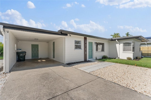 2715 Herwald St, Sarasota, FL 34231 - view of front of house with a carport, concrete driveway, and fence
