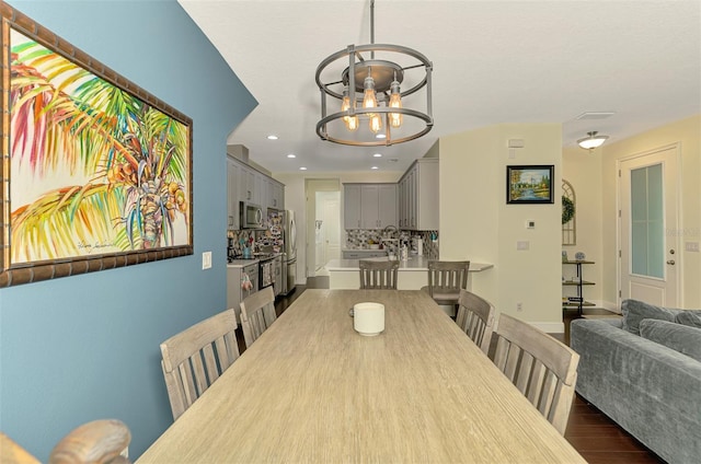4500 Chinkapin Dr, Sarasota, FL 34232 - dining area featuring dark wood finished floors, a chandelier, recessed lighting, and baseboards