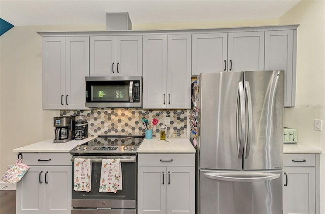 4500 Chinkapin Dr, Sarasota, FL 34232 - kitchen with appliances with stainless steel finishes, gray cabinetry, light countertops, and backsplash