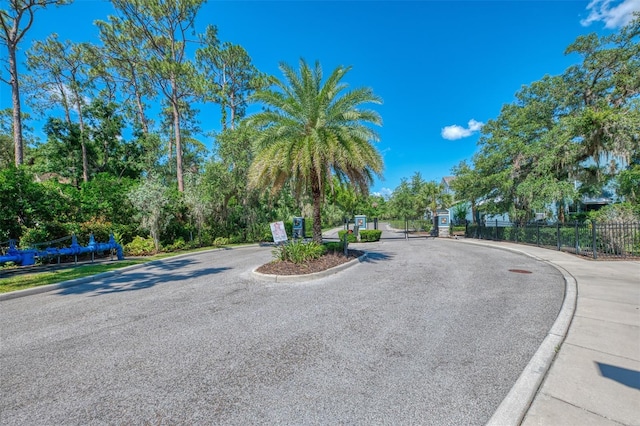 4500 Chinkapin Dr, Sarasota, FL 34232 - view of asphalt road with curbs, a gated entry, sidewalks, and a gate