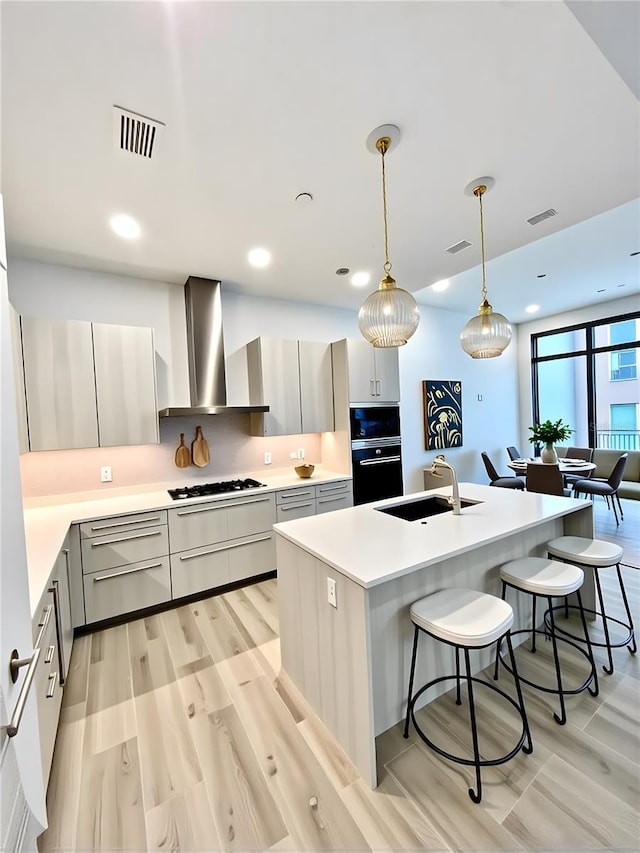 33 S Palm Ave Unit 1202, Sarasota, FL 34236 - kitchen featuring wall chimney exhaust hood, a sink, oven, gas cooktop, and a kitchen breakfast bar