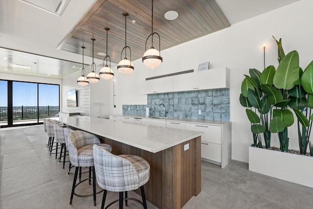 33 S Palm Ave Unit 1202, Sarasota, FL 34236 - kitchen featuring a sink, white cabinets, modern cabinets, decorative backsplash, and a large island