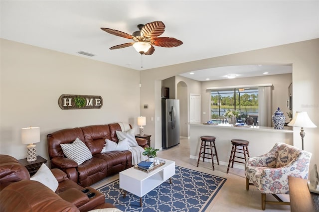 living room with ceiling fan, arched walkways, recessed lighting, and baseboards