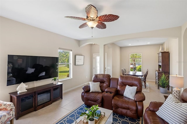 living area with arched walkways, light tile patterned floors, plenty of natural light, ceiling fan, and recessed lighting