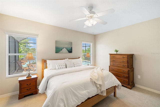bedroom with multiple windows, baseboards, and light tile patterned floors