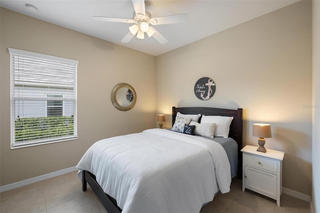 bedroom featuring baseboards, light tile patterned flooring, and a ceiling fan