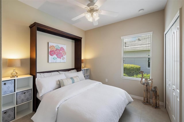 bedroom featuring light tile patterned flooring, a closet, baseboards, and ceiling fan