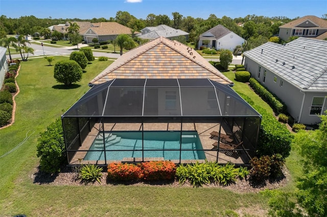 back of property with an outdoor pool, a lanai, a patio area, and a yard