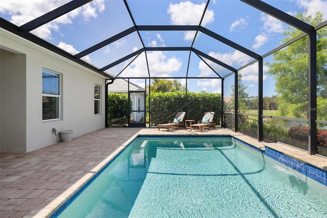 swimming pool with a patio and glass enclosure