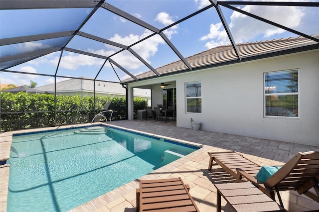 swimming pool featuring a patio, ceiling fan, and a lanai