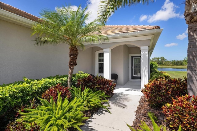 entrance to property with stucco siding and a water view