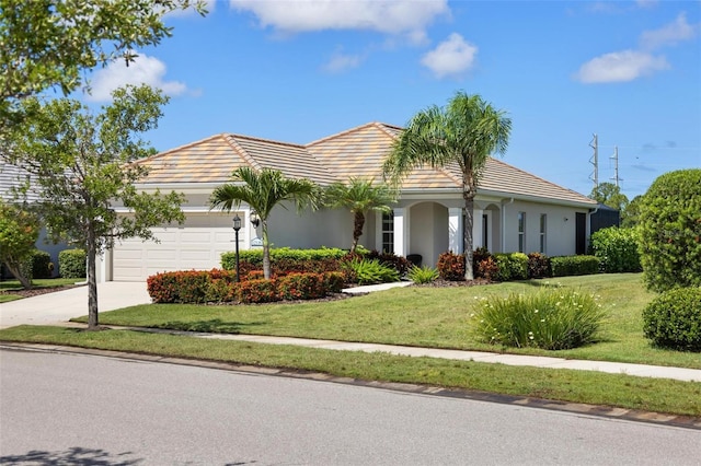 single story home featuring a tiled roof, an attached garage, a front yard, stucco siding, and concrete driveway