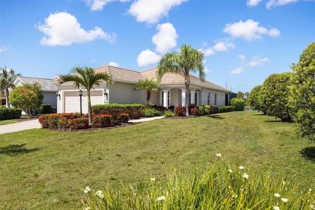 ranch-style house featuring a tile roof, stucco siding, an attached garage, a front yard, and driveway