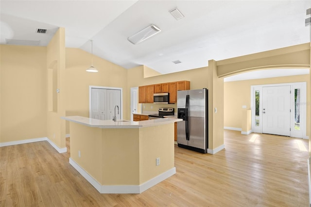 1399 Shields St, Punta Gorda, FL 33980 - kitchen featuring stainless steel appliances, a sink, light countertops, brown cabinets, and lofted ceiling