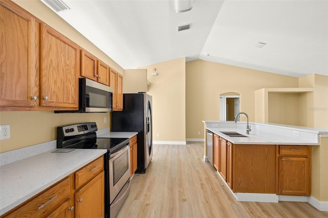 1399 Shields St, Punta Gorda, FL 33980 - kitchen featuring appliances with stainless steel finishes, a sink, light wood-style floors, vaulted ceiling, and a kitchen island with sink