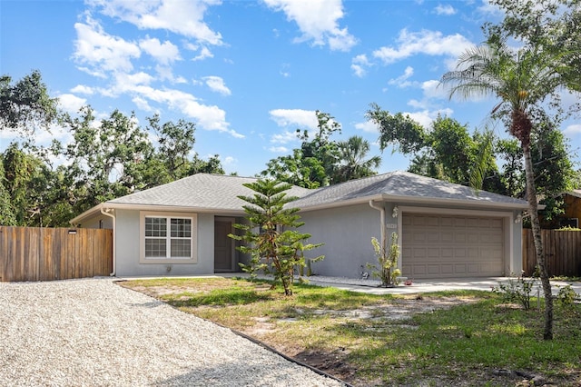 1345 24th St, Sarasota, FL 34234 - view of front of property featuring stucco siding, driveway, and a garage