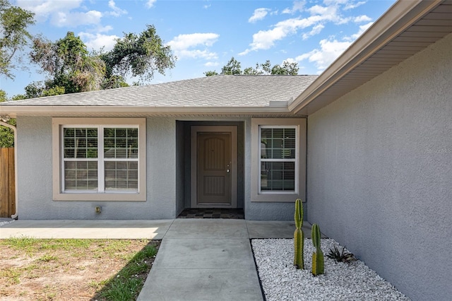 1345 24th St, Sarasota, FL 34234 - view of exterior entry featuring stucco siding and roof with shingles
