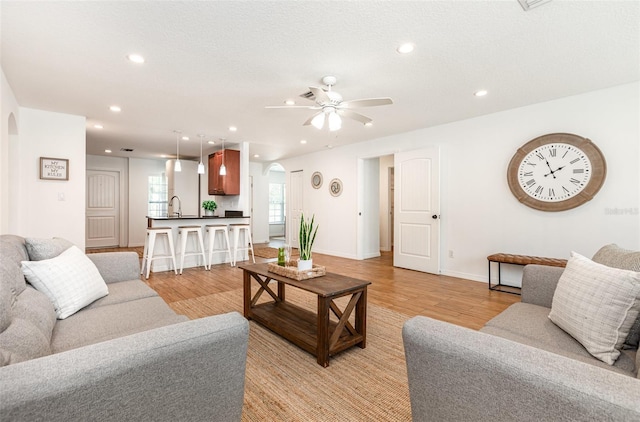 1345 24th St, Sarasota, FL 34234 - living room featuring arched walkways, light wood-type flooring, recessed lighting, ceiling fan, and baseboards