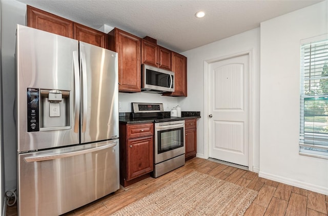 1345 24th St, Sarasota, FL 34234 - kitchen featuring appliances with stainless steel finishes, light wood-style floors, baseboards, recessed lighting, and a textured ceiling