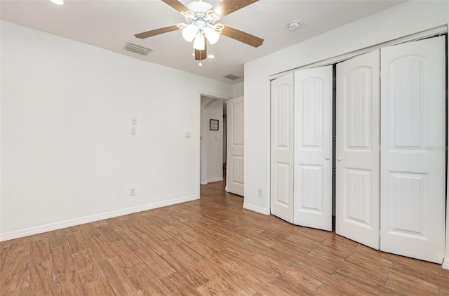 1345 24th St, Sarasota, FL 34234 - unfurnished bedroom featuring light wood finished floors, a closet, baseboards, arched walkways, and recessed lighting
